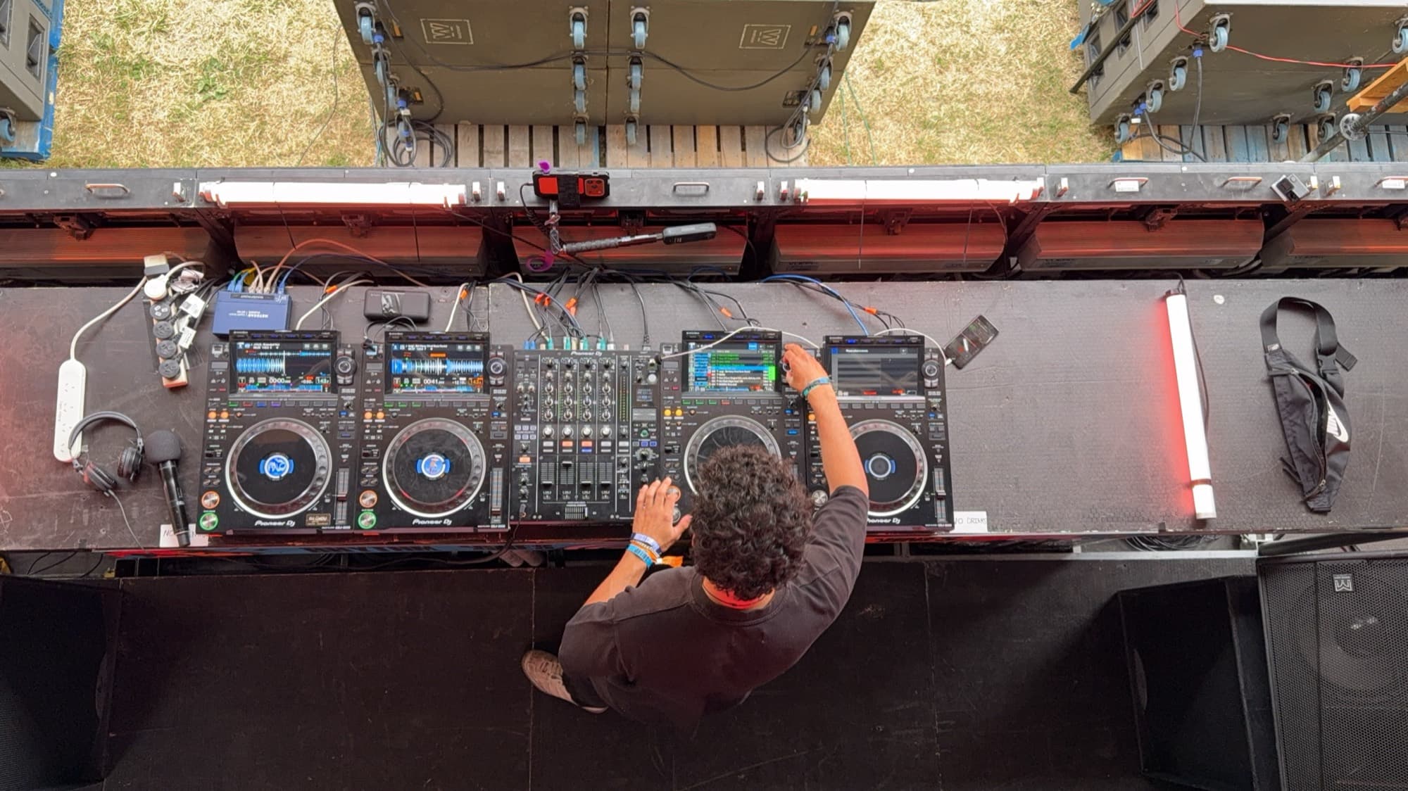 Overhead view of a DJ working four decks and a mixer